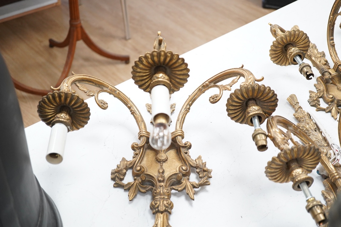 A set of four Louis XVI style three branch gilt bronze wall lights, 62.5cm high x 40cm wide